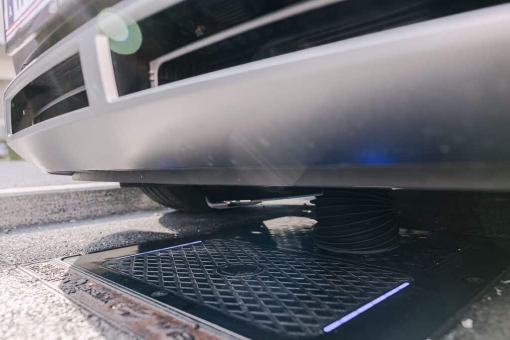 e Taxi Austria 1 Unterseite eines Elektrofahrzeugs beim automatisierten kabellosen Laden mit Matrix-Charging-Technologie.