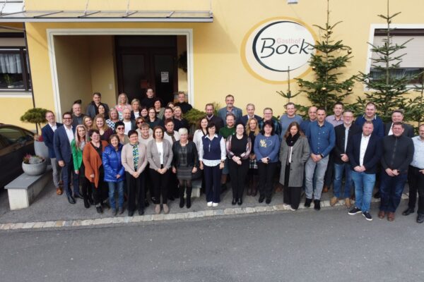 Gruppenfoto der langjährigen Mitarbeiterinnen und Mitarbeiter der BECOM Group vor dem Gasthof Bock in Rettenbach.