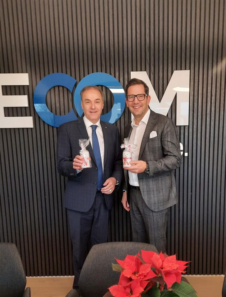 gemeinsam-gutes-tun-1 Vertreter von BECOM bei einem vorweihnachtlichen Treffen mit symbolischen Geschenken und sozialem Engagement.